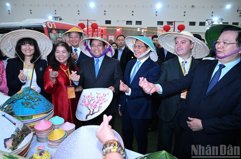 Премьер-министр Фам Минь Тьинь и делегаты осматривают выставочные стенды на ярмарке.
