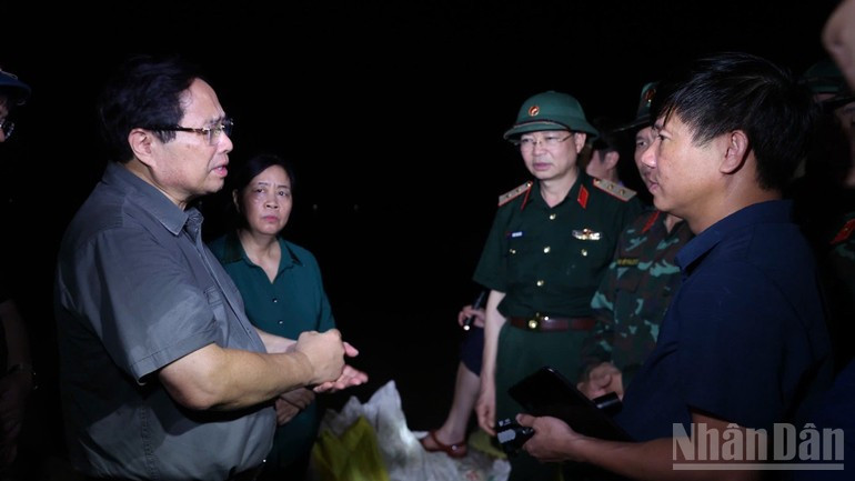 Премьер-министр Фам Минь Тьинь обсуждает варианты реагирования с руководством города Ханоя, представителями ведомств и оперативных служб на месте происшествия. Фото: Чан Хай