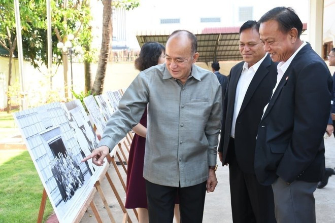 Участники осматривают фотовыставку, посвящённую Президенту Хо Ши Мину, Президенту Кайсону Фомвихану и руководителям двух партий и двух государств. (Фото: ВИА)