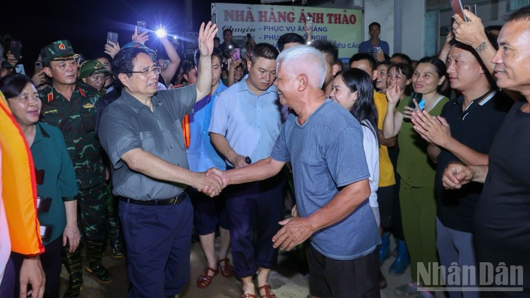 Премьер-министр Фам Минь Тьинь поддерживает жителей районов, находящихся под угрозой затопления. Фото: Чан Хай