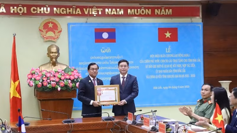 Губернатор провинции Секонг Леклай Сивилай вручает Орден Труда первой степени от Правительства Лаоса представителю руководителей провинции Даклак.