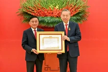 Постоянный член Секретариата Чан Кам Ту вручает знак «45 лет членства в Партии» Генеральному секретарю ЦК КПВ То Ламу. Фото: Зюи Линь