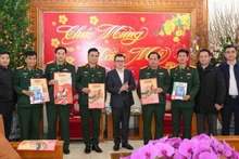 Товарищ Ле Куок Минь (в центре) вручает 325-й дивизии новогодние номера газеты.