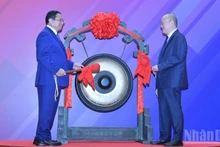 Премьер-министр Фам Минь Тьинь и руководитель Шанхайской фондовой биржи проводят церемонию удара в гонг. Фото: Тхань Жанг