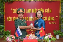Генерал-майор Лыу Чонг Лы передает урну с землёй директору Музея Победы Дьенбьенфу Ву Тхи Тует Нга. Фото: ВИА