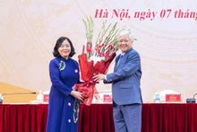 Постоянный замсекретаря Парткома НС, бывший Председатель ЦК ОФВ До Ван Тьиен вручает цветы с поздравлением товарищу Буй Тхи Минь Хоай.