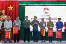 Премьер-министр Фам Минь Тьинь вручает подарки семьям жилого района Тхангкиен общины Деги. Фото: VGP