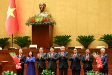 Руководители Партии и Государства вручают цветы Заместителю председателя НС До Ван Тьиену и Председателю Верховного народного суда Нгуен Ван Куангу. Фото: Зюи Линь