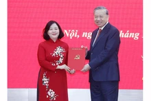 Генеральный секретарь ЦК КПВ То Лам вручает Решение Политбюро о назначении товарища Буй Тхи Минь Хоай на должность секретаря партийной организации Отечественного фронта и центральных массовых организаций. Фото: ВИА