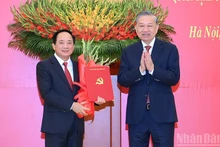 Генеральный секретарь ЦК КПВ То Лам вручает решение Политбюро о назначении товарища Чинь Ван Куета на должность Заведующего Отделом ЦК КПВ по пропаганде, политическому воспитанию и работе с народными массами. Фото: Данг Кхоа