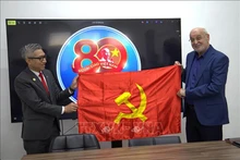 Посол Вьетнама в Израиле Ли Дык Чунг вручает знамя КПВ товарищу Иссаму Махулу. Фото: ВИА