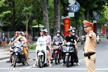 Сотрудник дорожной полиции регулирует движение транспорта в Ханое. Фото: ВИА