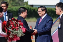 Должностные лица Лаоса приветствуют Премьер-министра Фам Минь Тьиня. Фото: VGP