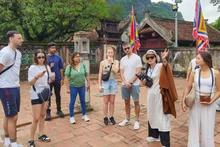 Иностранные туристы осматривают исторический памятник — храм королей Динь и Ле в древней столице Хоалы (провинция Ниньбинь). Фото: ВИА