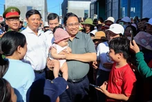 Премьер-министр Фам Минь Тьинь посещает жителей зоны переселения Куангдык в общине Тюианнам провинции Даклак. Фото: VGP 