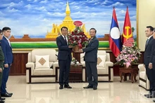 Посол Нгуен Минь Там (справа) вручает корзину цветов товарищу Бунлеуа Фанданувонгу.