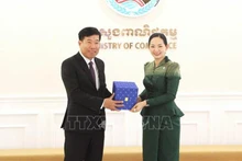 Заместитель министра иностранных дел Нгуен Мань Кыонг и Министр торговли Камбоджи Чам Нимул обмениваются памятными подарками. Фото: ВИА