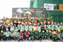 Руководители АО «Coteccons», представители подразделений и подрядчики фотографируются на память с рабочими на мероприятии.