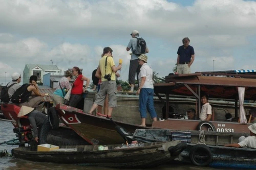 Иностранные туристы осматривают плавучий рынок Кайранг (Кантхо).