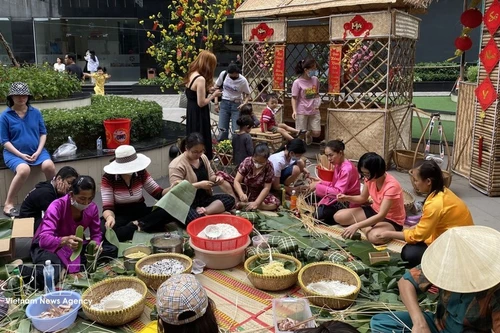 Жители жилого комплекса «Анфу» (город Тхудык) вместе заворачивают баньчынг, готовясь к празднованию Тэта. (Фото: ВИА)