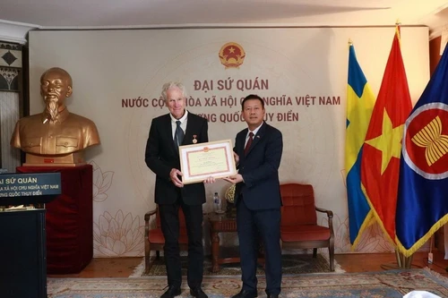 Посол Чан Ван Туан вручил медаль «За заслуги в области культуры, спорта и туризма» кинорежиссёру Бо Элену. (Фото: Посольство Вьетнама в Швеции)
