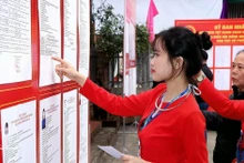 Избирательница народности Мыонг, впервые участвующая в выборах, внимательно изучает биографию кандидатов. Фото: ВИА