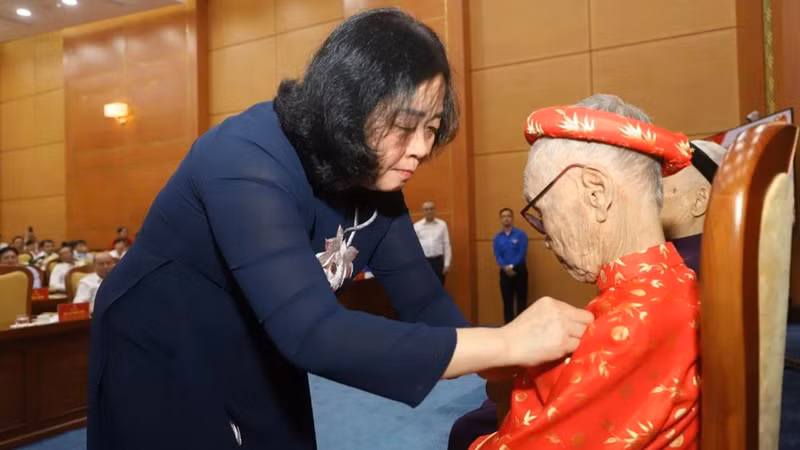 Председатель ЦК ОФВ Буй Тхи Минь Хоай вручает почетный знак «80 лет членства в Партии» члену Партии с многолетним партийным стажем в провинции Футхо. Фото: Нгок Лонг