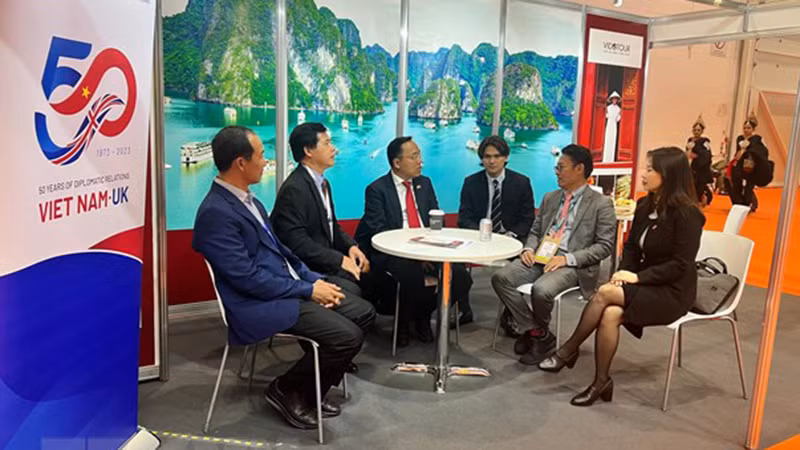 Посол Вьетнама в Великобритании Нгуен Хоанг Лонг (третий слева) разговаривает с представителями предприятий, участвовавших в ярмарке.