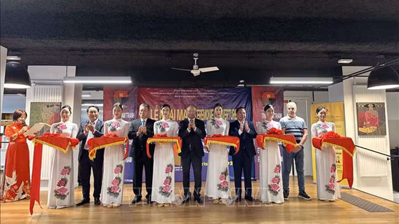 Делегаты разрезают ленту в знак открытия выставки вьетнамских лаковых картин и изделий. Фото: ВИА