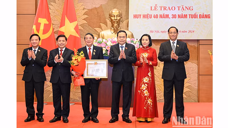 Руководители НС вручают поздравительные цветы Зампредседателя НС Нгуен Дык Хаю. Фото: Зюи Линь