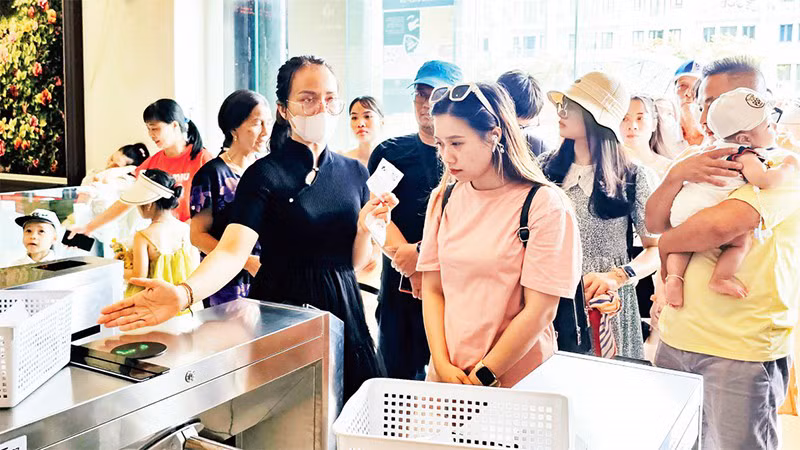 Туристы используют электронные билеты для сканирования QR-кодов при посещении Музея Куангнинь. Фото: Лыонг Куанг Тхо