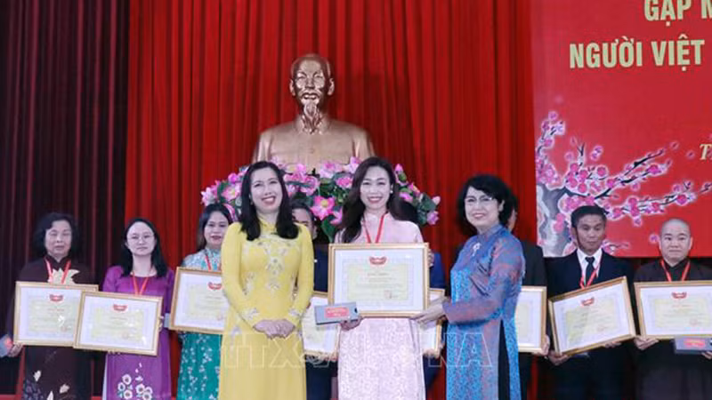 Зампредседателя ЦК ОФВ То Тхи Бить Тяу (справа) и Замминистра Ле Тхи Тху Ханг вручают похвальные грамоты выдающимся отдельным лицам. Фото: ВИА