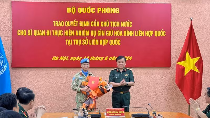 Генерал-полковник Хоанг Суан Тьиен вручает решение полковнику Чыонг Ань Туану. 