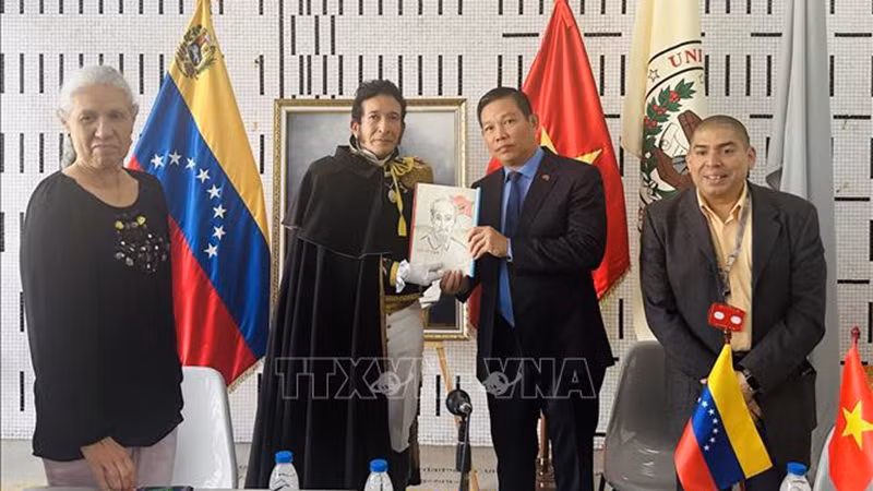 Кандидат наук Хуан Гамес, преподаватель Университета Боливар вручает Послу Вьетнама в Венесуэле Ву Чунг Ми фотографию Президента Хо Ши Мина, нарисованную им самим. Фото: ВИА