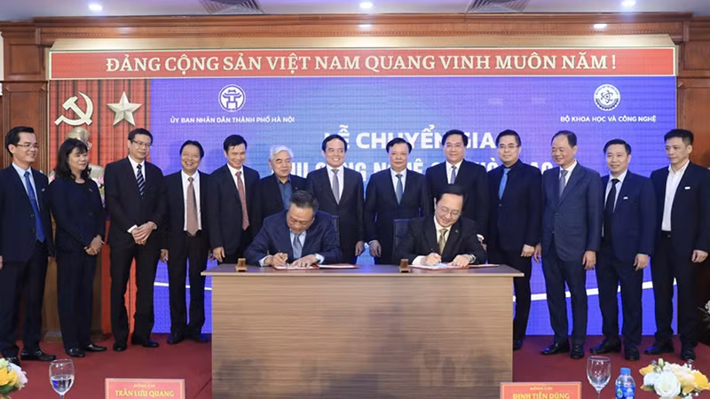 Председатель Народного комитета г. Ханоя Чан Ши Тхань и Министр науки и технологий Хюинь Тхань Дат подписывают протокол о передаче парка высоких технологий Хоалак Народному комитету г. Ханоя. Фото: qdnd.vn