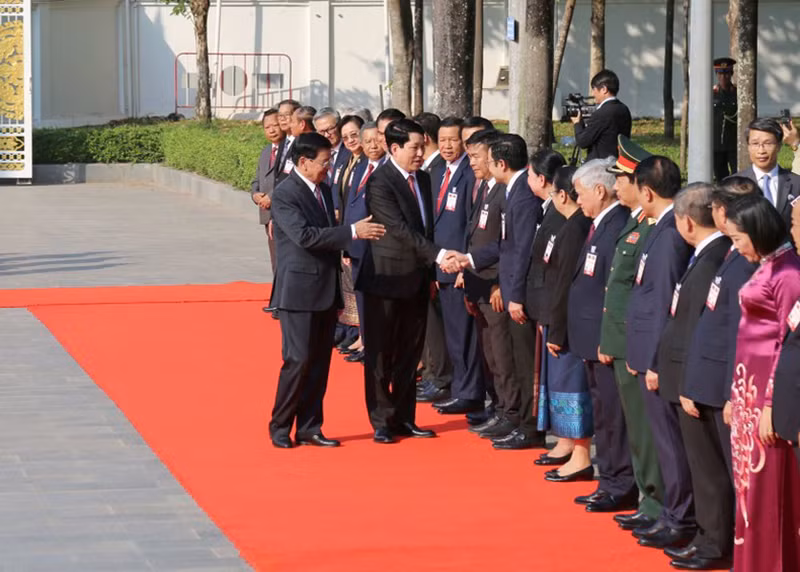 Президент Вьетнама Лыонг Кыонг пожимает руки лаосским делегатам.