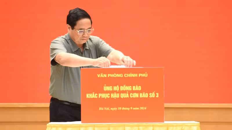 Премьер-министр Фам Минь Тьинь дает пожертвования в поддержку людей, пострадавших от тайфуна №3. Фото: Чан Хай