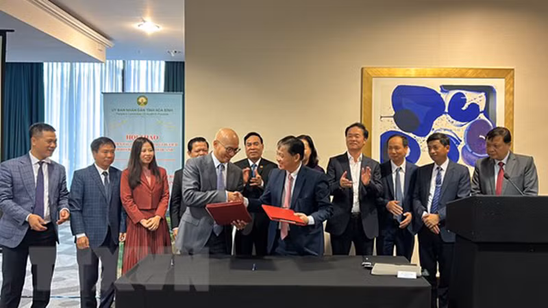 Председатель Народного комитета провинции Хоабинь Буй Ван Кхань и председатель Общества вьетнамских предприятий в Великобритании Пол Хоанг подписывают документ о сотрудничестве. Фото: ВИА