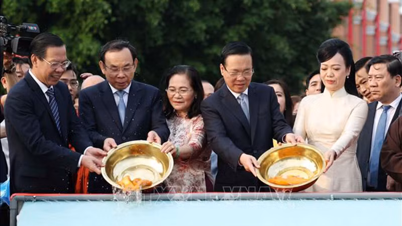 Президент Во Ван Тхыонг c супругой и делегаты проводят ритуал спуска карпа в воду. Фото: ВИА