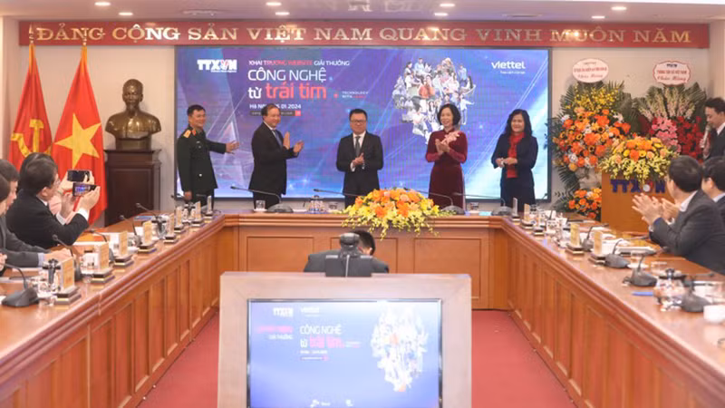 Делегаты нажимают кнопки в знак открытия веб-сайта премии. 