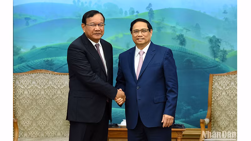 Премьер-министр Фам Минь Тьинь (справа) и Заведующий Отделом по внешним связям ЦК НПК Прак Сокхонн. Фото: Чан Хай