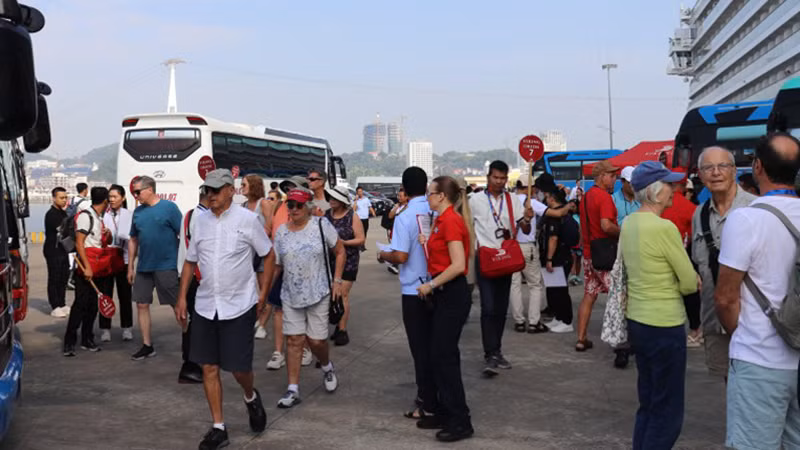 Представители туристических агентств принимают туристов в международном порту Хонгай. 