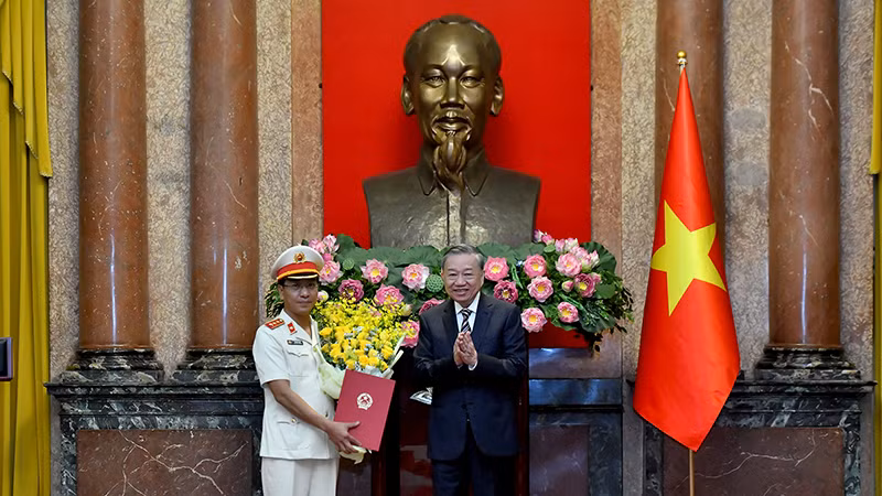 Генеральный секретарь ЦК КПВ, Президент То Лам вручает решение товарищу Хо Дык Аню.