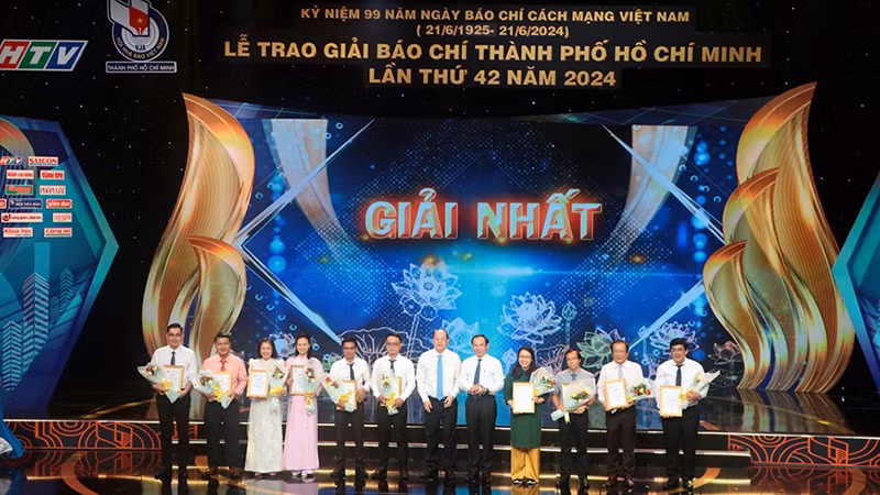 Руководители г. Хошимина вручают первые призы авторам и группам авторов. Фото: qdnd.vn