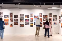 Гости посещают фотовыставку, посвященную Вьетнаму и его народу.