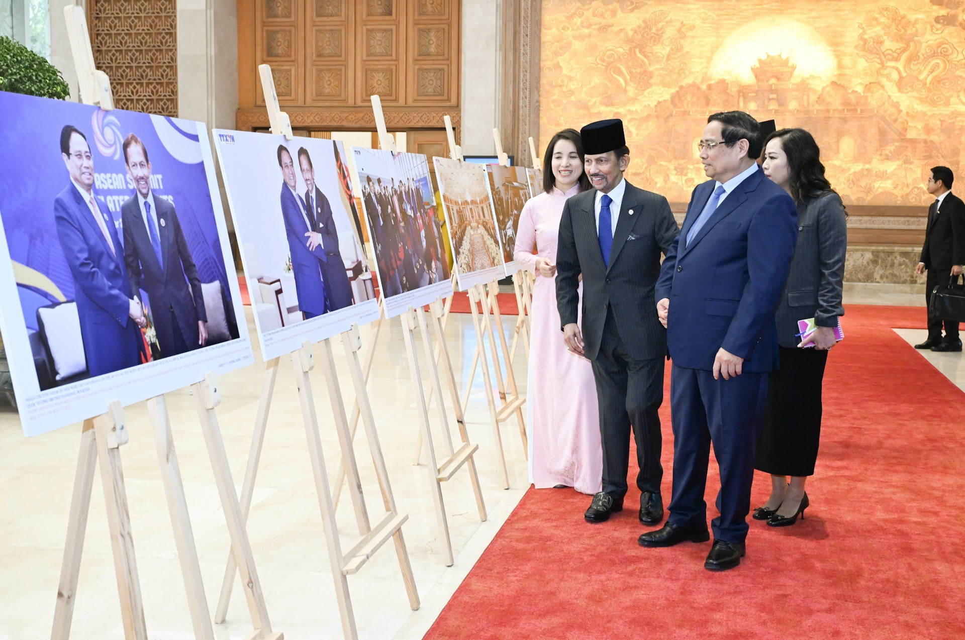 Премьер-министр Фам Минь Тьинь и Султан Хаджи Хассанал Болкиах смотрят фотографии о сотрудничестве между двумя странами.