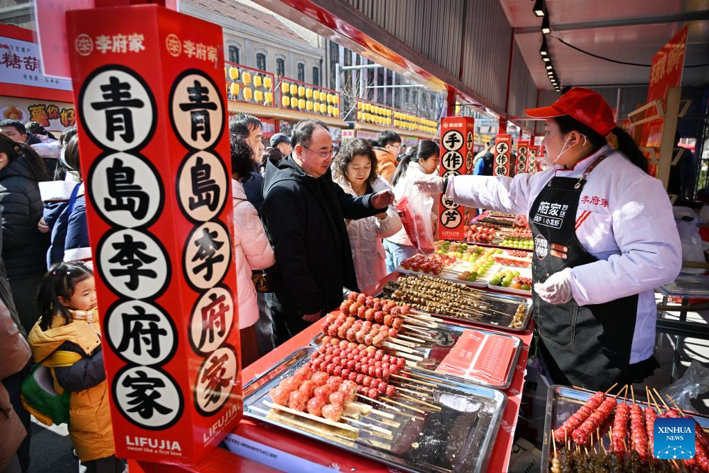 Посетители осматривают и приобретают товары на ярмарке с традиционной продукцией и фирменными блюдами в городе Циндао (провинция Шаньдун, Китай), 17 февраля 2026 года.