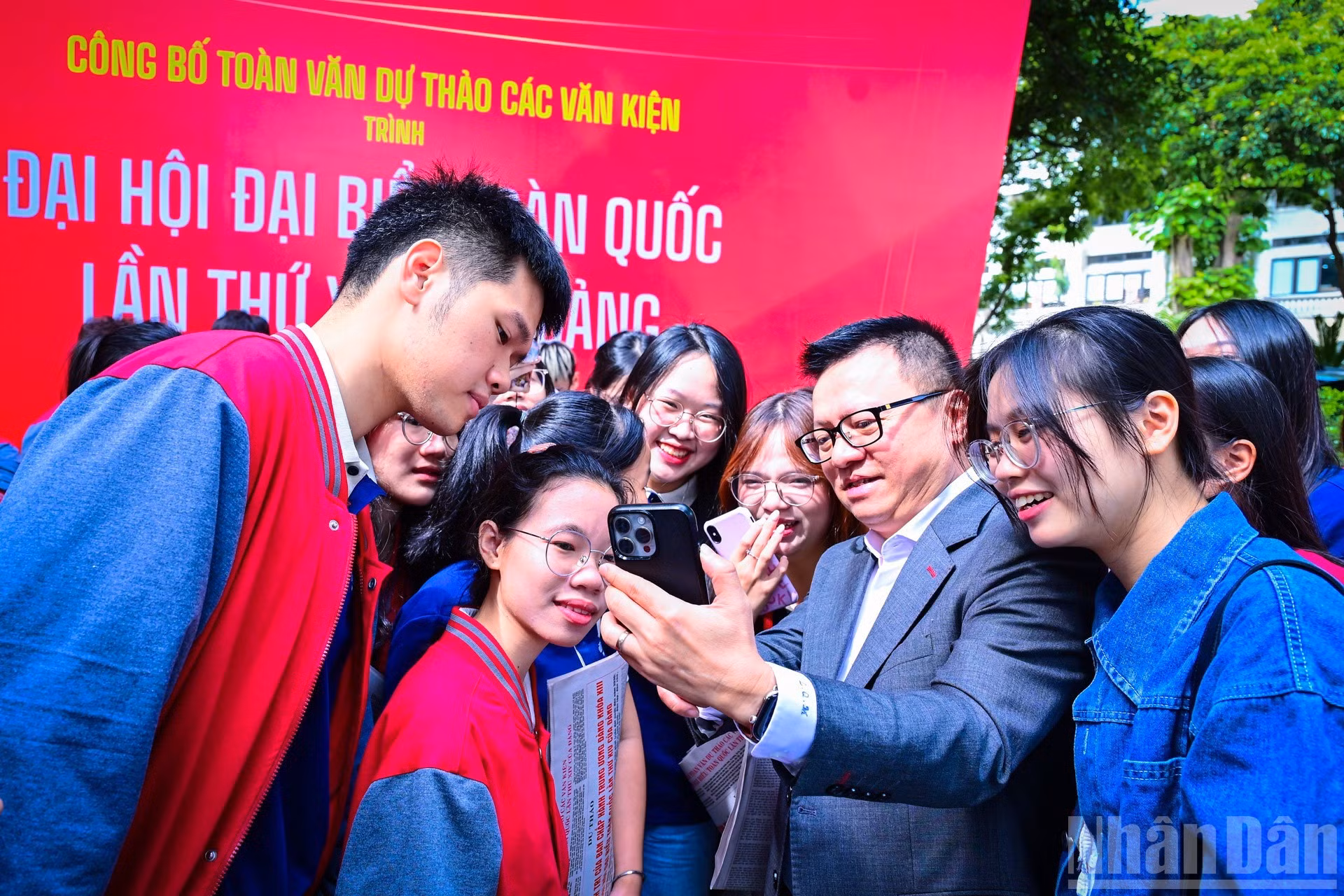 Главный редактор газеты «Нянзан» Ле Куок Минь показывает молодежи, как воспользоваться официальным интернет-порталом XIV съезда КПВ для внесения предложений к проектам документов.