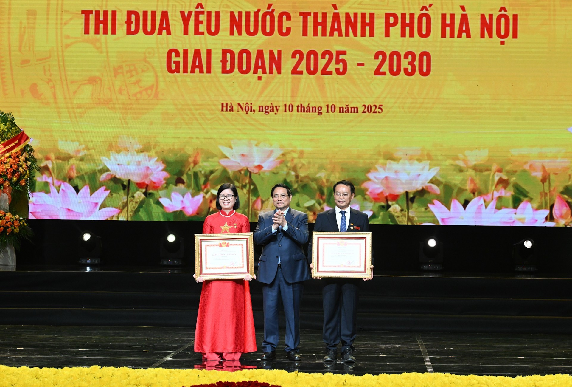 Премьер-министр Фам Минь Тьинь вручает сертификат о звании «Общенациональный соревновательный борец» двум лицам.