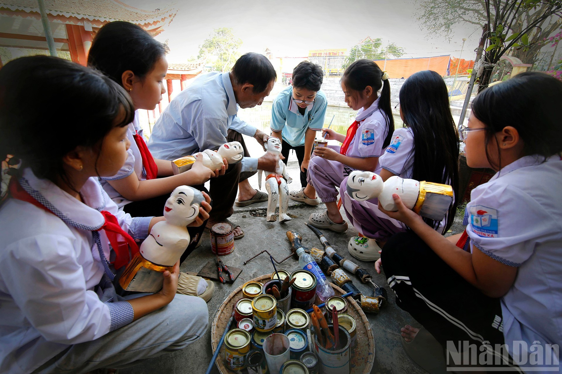 Мастер обучает школьников росписи и украшению кукол.